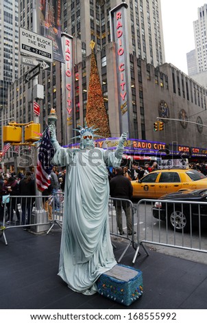NEW YORK - DECEMBER 19:  Unidentified street performer poses as a Statue of Liberty in the front of  New York City landmark Radio City Music Hall in Rockefeller Center on December 19, 2013.