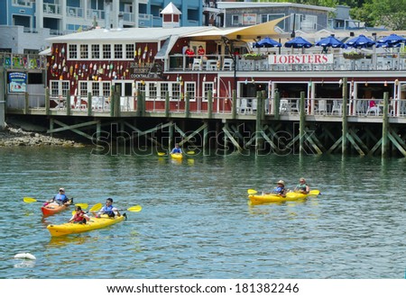 BAR HARBOR, MAINE - JULY 6: Tourists riding sea kayaks in Bar Harbor on July 6, 2013. Bar Harbor is a famous summer colony in the Down East region of Maine