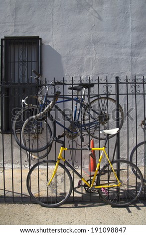 BROOKLYN, NEW YORK - MAY 1 Old bicycles parked and locked to metal gate in Williamsburg, Brooklyn on May 1, 2014. Williamsburg is an influential hub of hipster culture, and the local art community