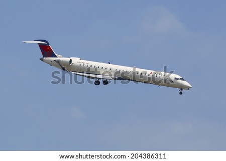 NEW YORK - JULY 8  Delta Connection Bombardier CRJ-900 in New York sky before landing at JFK Airport on July 8, 2014  Delta Air Lines and its subsidiaries operate over 5000 flights every day