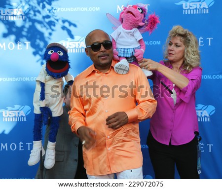 NEW YORK - AUGUST 25 Star of ABC Shark Tank Daymond John with Sesame Street\'s Grover and Abby Cadabby at the red carpet before US Open 2014 opening night ceremony on August 25, 2014 in New York