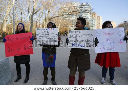 BROOKLYN, NEW YORK - DECEMBER 14: A protesters hold a signs during a march against police brutality and grand jury decision on Eric Garner case on Grand Army Plaza in Brooklyn on December 14, 2014