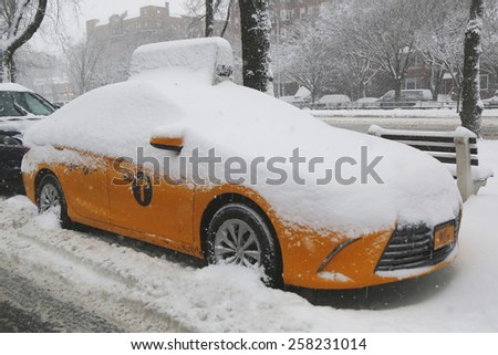 BROOKLYN, NEW YORK - MARCH 5, 2015: New York Yellow taxi under snow in Brooklyn, NY during massive Winter Storm Thor