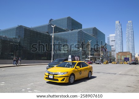 NEW YORK - APRIL 24, 2014: Yellow taxi in front of Javits Convention Center in Manhattan. The convention center has a total area space of 1,800, 000 square ft and has 840,000 square ft of total space