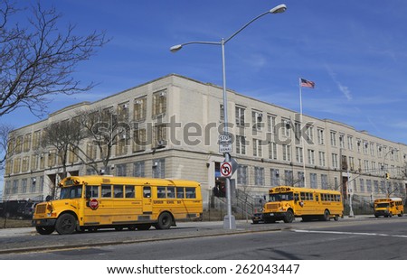 BROOKLYN, NEW YORK - MARCH 19, 2015: School buses in the front of public school in Brooklyn. New York City has the largest school transportation department in the country.