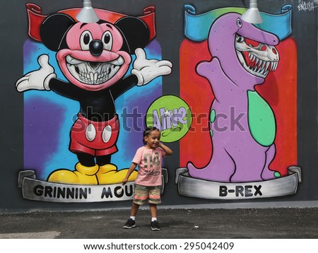 NEW YORK - JUNE 30, 2015: Unidentified child in the front of the mural art at the new street art attraction Coney Art Walls at Coney Island section in Brooklyn