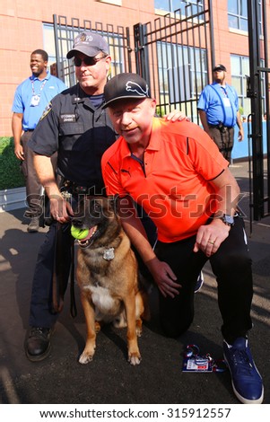 NEW YORK - AUGUST 29, 2015: Six times Grand Slam champion Boris Becker with NYPD transit bureau K-9 police officer and Belgian Shepherd Wyatt  at National Tennis Center during US Open 2015 in New York