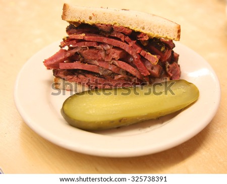 Famous Pastrami on rye sandwich served with pickle in New York Deli