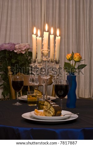 Romantic table for two served with dessert (cake and fruits).