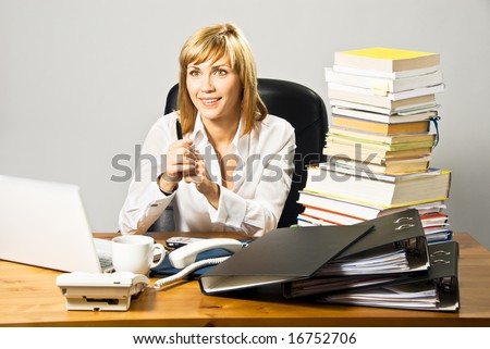 Young beautiful business lady working at a busy desk.