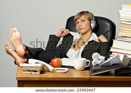Lazy Businesswoman or Student with headphones at a busy office desk.