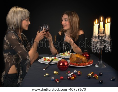 Beautiful female friends/sisters having a dinner, drinking wine.