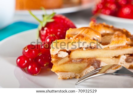 Apple pie served with red currants and strawberry.