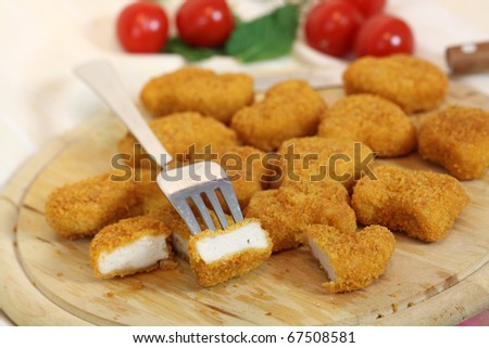 Studio shooting of a fried chicken pieces (nuggets) on wooden desk