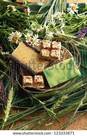 handmade soap with melissa, chamomile, poppy seeds on the background of wild flowers