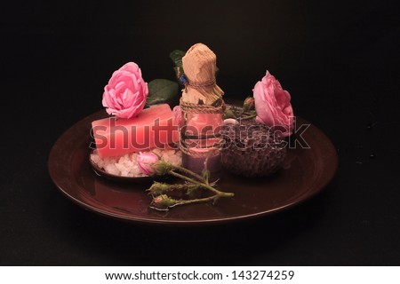 rose oil with flower roses on a plate made of clay