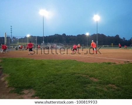 Men\'s evening softball game under the lights