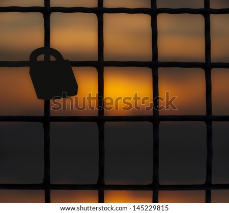 metal fence with padlock in back light with warm colors