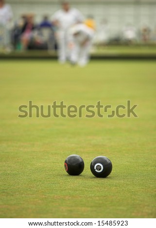 A game of lawn bowls. Focus on the woods.