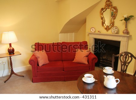 Afternoon tea in traditional english room with sofa and fireplace