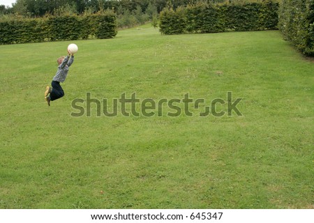 Small Boy jumping in air to catch ball