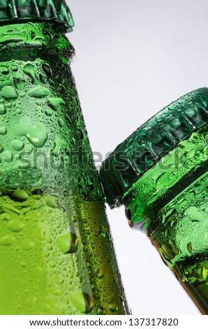 macro photography of two bottles of beer on white background