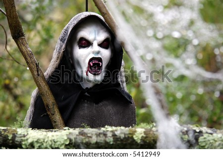 Decorative hooded Ghoul with bloodied mouth and fangs.