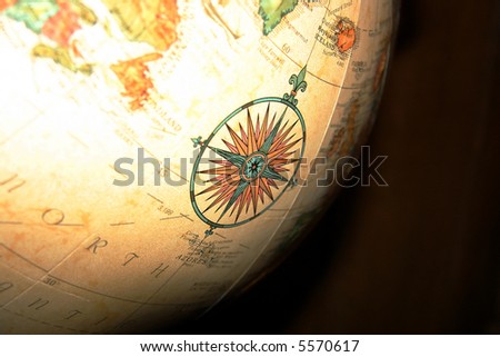 An ornate compass detail illustration on a large spinning globe.