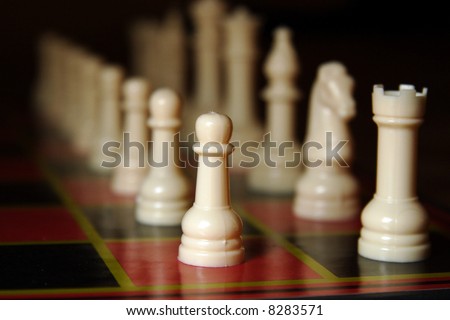 The white side of a chess set, lined up for the start of the game, fading into the distance.