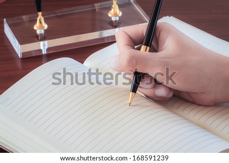 male hand signing a contract on blank white paper.