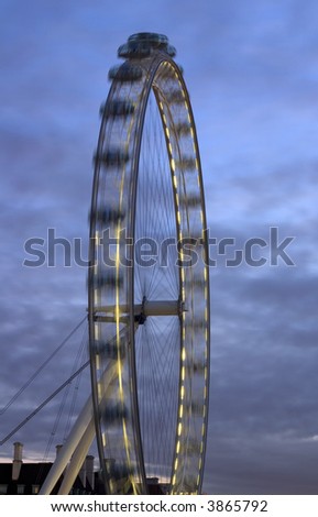 Fragment of the London Eye at night with motion and dark blue sky.