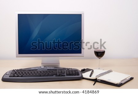 Computer in office with calendar, pen  and glass of wine. Switch on