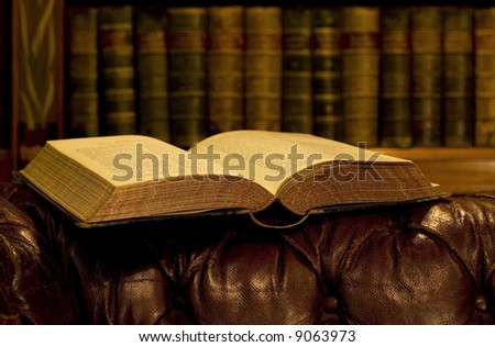 Open book on leather old couch
