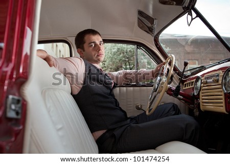 Man is sitting in the vintage car.