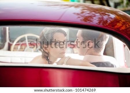 Pretty couple in the back seat of the vintage car.