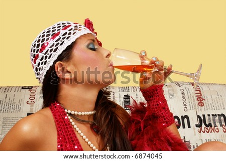 Girl in the hat with glass of wine. Isolated on yellow.