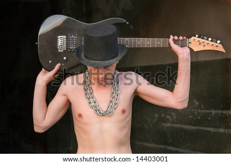 stock photo Portrait of naked boy with electric guitar in a black hat