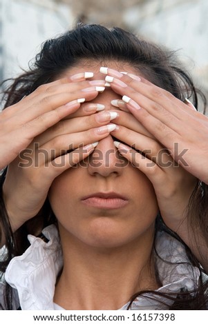 Girl\'s face with eyes closed by hands.