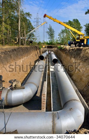 A group of workers are constructing a trunk pipeline in the ditch.