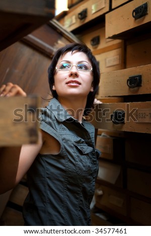 Sexy girl is trying to find something in the old archive.