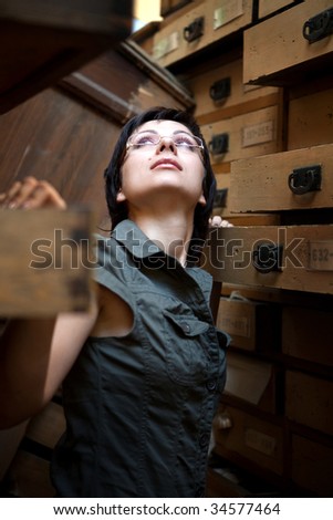 Sexy girl is trying to find something in the old archive.