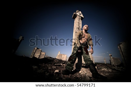 Bloody zombie in the military uniform under the radiation sign on the ruined buildings background.