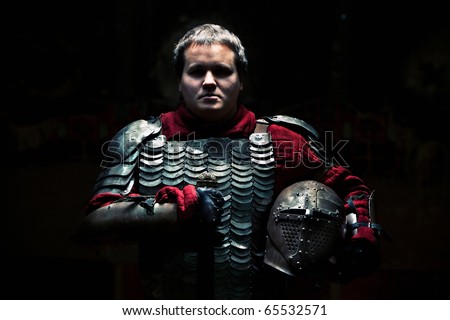 Medieval knight in the armor with the sword and helmet.