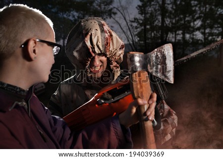 Woman fights with the maniac, axe against chainsaw