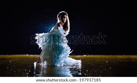 Beautiful white angel is standing in the water.