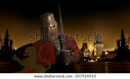 Medieval knight in the armor with the sword and shield. Castle on the background.