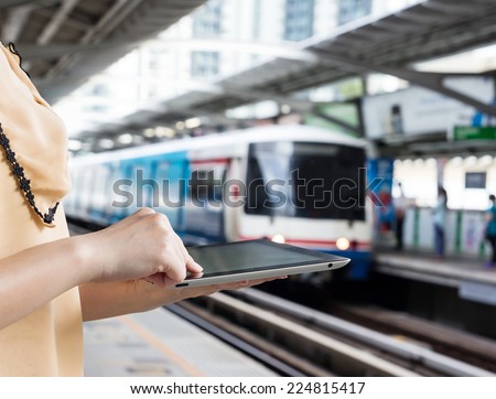 Woman using digital tablet at skytrain station