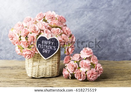 Happy mothers day concept of Paper carnation in weave basket on old wood with copy space