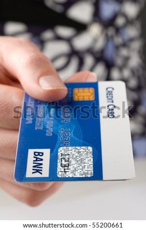 Woman pays a bill with credit card.Focus on foreground.