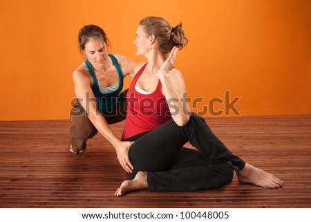 Coach and student in yoga workout clothes